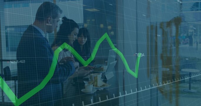 Meeting team reviewing laptop data in lobby, with phone, tablet, coffee, green chart, wearing suits