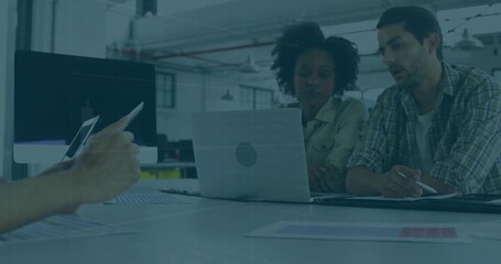 Discussing charts, colleagues in light shirt and plaid shirts leaning over laptop in office