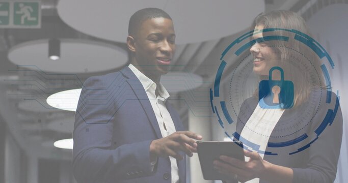 Pointing man in navy suit, holding woman in dark blazer reviewing security in office, tablet HUD - Powered by Adobe