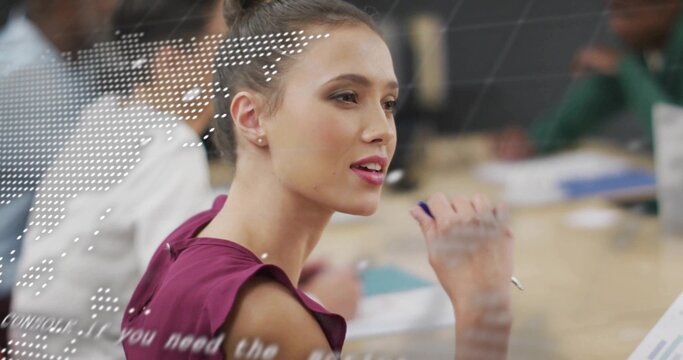 Speaking woman in magenta sleeveless blouse holding pen by face at meeting table, dotted overlay