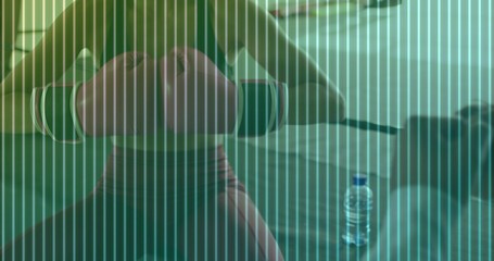 Performing dumbbell chest press male lifter on bench at home wearing tank top and shorts