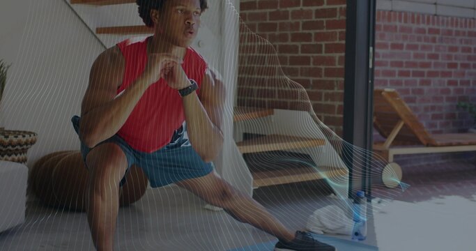 Performing man in red sleeveless top, blue shorts lunging in home with mat, water bottle