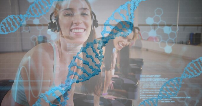 Smiling headphone-clad woman in activewear leading group on steps in studio with DNA code overlays - Powered by Adobe