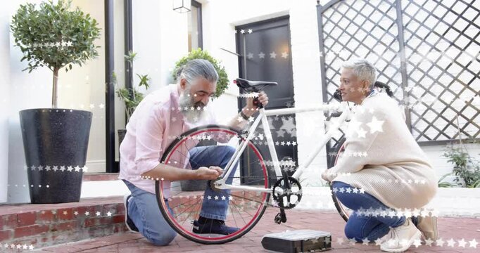Man and woman kneeling in courtyard, retrieving wrench and adjusting red-trimmed rear wheel for DIY