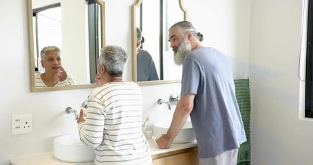 Woman using skincare jar, man leaning reaching, blue overlay sweeping across mirror obscuring faces