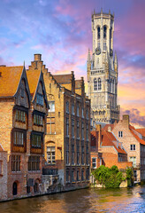 Bruges, Belgium. View at medieval bell tower Belfort van Brugge in old town. Vintage houses on canals. Old Europe landscape, popular travel destination.