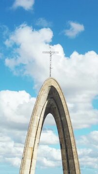 Catholic Church with cross on top on blue sky background with clouds. Vertical footage