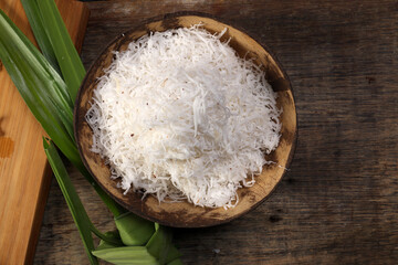 Traditional Malaysian desert Nonyah Kuih making preparing ingredients panadn leaf shredded coconut gula melaka  agar agar sagu spread over black slate messy rustic wood