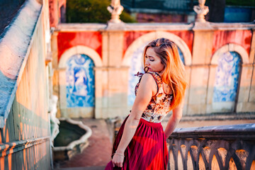 Woman in red dress at Estoi Palace gardens in the Algarve, Portugal