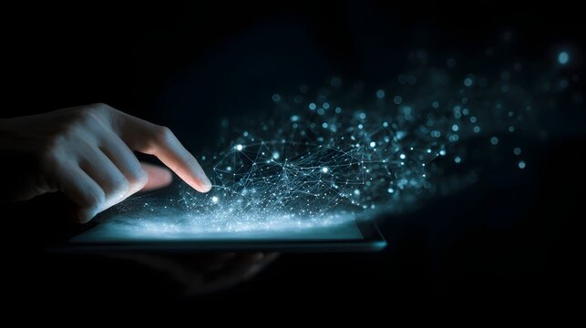 Hand touching glowing digital tablet with abstract light particles.