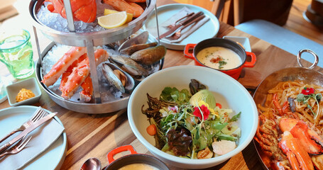 Gourmet seafood platter with crab, mussels, shrimp, paired with fresh salad in elegant restaurant setting. Captures luxury dining experience, perfect for culinary themes.