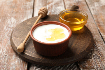 Delicious Greek yogurt with honey on wooden table, closeup