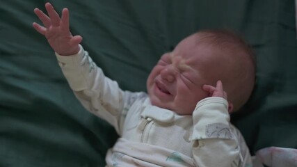 vertical screen newborn appearing upset with tearful expression, crying infant on blanket displaying visible distress and tears, distressed newborn with clenched fists and tearfilled eyes - Powered by Adobe