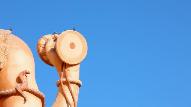 shiva idol arm with sacred damru and serpent captured in bright sunlight