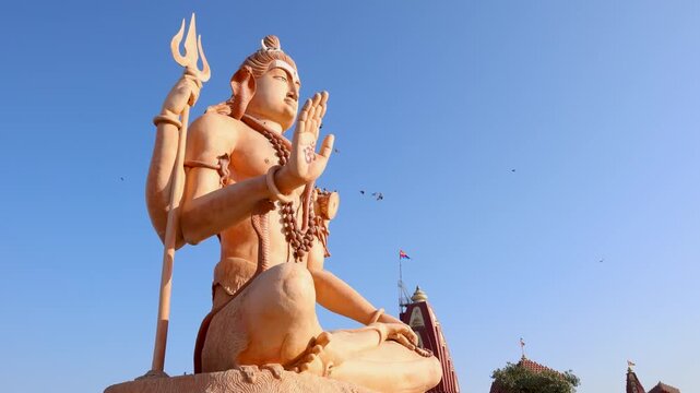 divine shiva sculpture with trident and damru photographed from low angle