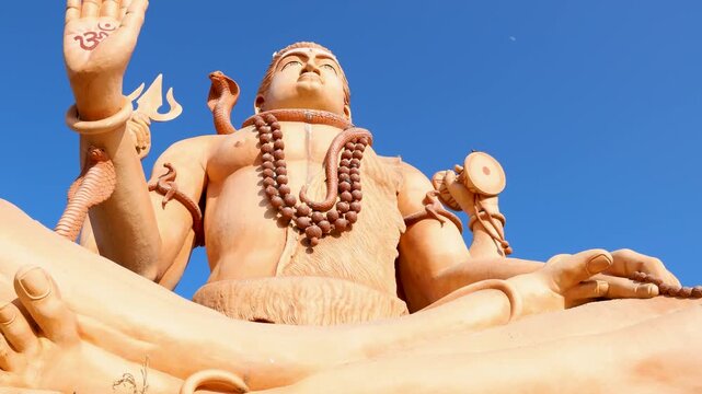 serene shiva idol with traditional attributes under clear sunny sky from low angle