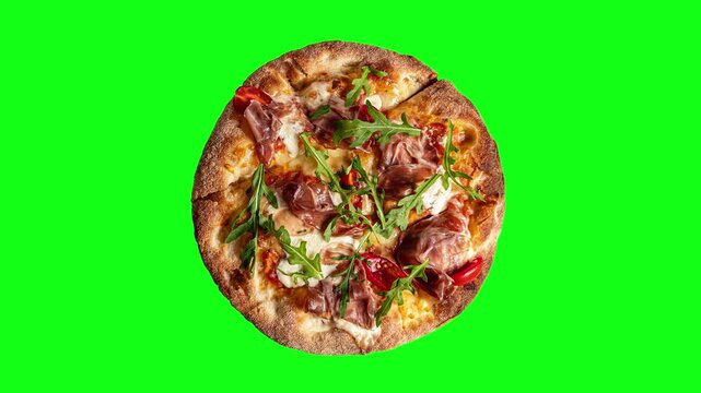 Prosciutto pizza with strachatella cheese, tomatoes and arugula leaves, top view, closeup object. Rotating on green background