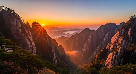 Sunburst over the huangshan mountains in china during a beautiful sunrise