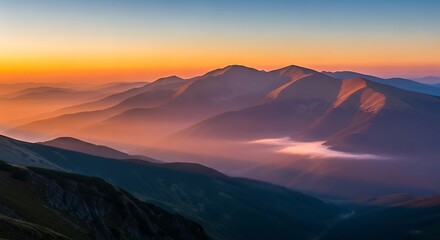 Mountains shrouded in mist catch the warm glow of the setting sun