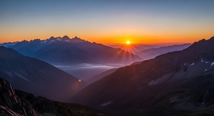 Golden sunrise paints the mountain peaks with vibrant colors and light rays