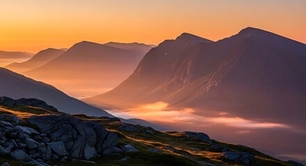 Scenic mountain range at sunrise with fog rolling through the valleys