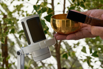 ASMR meditation sound. Hands playing small brass singing bowl near mic.