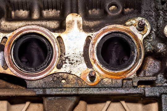 Internal view of cylinder head intake port showing carbon deposits and surface corrosion