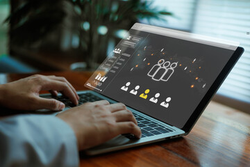 A person working on a laptop with a digital HR dashboard displaying candidate profiles and analytics, representing online recruitment, workforce management, and modern human resources technology.