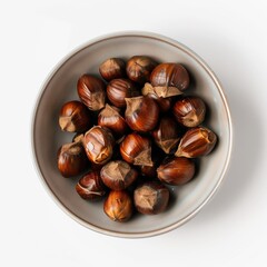Obraz premium Flat lay of roasted chestnuts in bowl on white background, clean studio mockup, food concept.