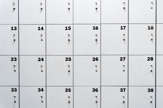 White numbered locker doors creating a pattern, representing personal storage and security in a public space like a gym or school