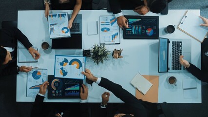 Top down aerial view businessman present marketing statistic graph to investor at meeting table. Group of diverse project manager analyze investment data while looking at financial chart. Directorate.