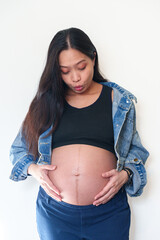 pregnancy, love, family and people concept - close up of pregnant woman making hand heart gesture on her belly
