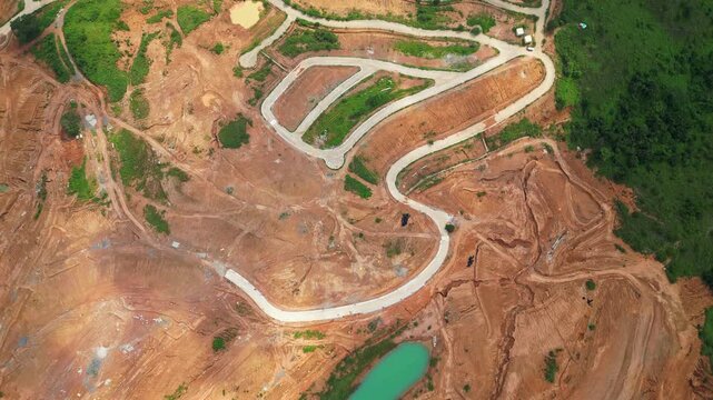 Top‑view aerial of Tandatangan Signature Golf Course in Mariveles, Bataan, showing green fairways with winding paved roads curving through the hilly landscape.