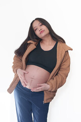 Beautiful young pregnant woman in good fit holds hands on her belly. Happy mother waiting for baby birth during pregnancy.