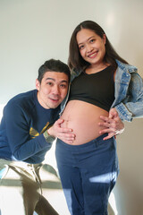 Emotional man listening to his pregnant wife belly