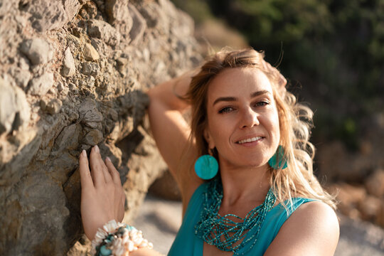 Woman nature serene, beautiful woman smiling by rocky beach during golden hour, natural charm