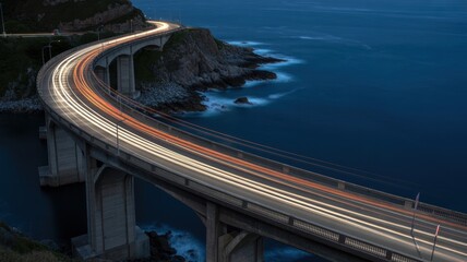Long exposure of a bridge at night with light trails from cars and ocean view from above angle