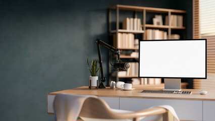 Fototapeta premium White screen computer and mic with headphones for radio or podcast on wooden table in office studio.