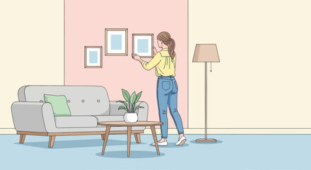 Woman decorating living room by hanging picture frames