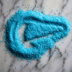 Bright blue bath salts on a marble surface for spa treatment