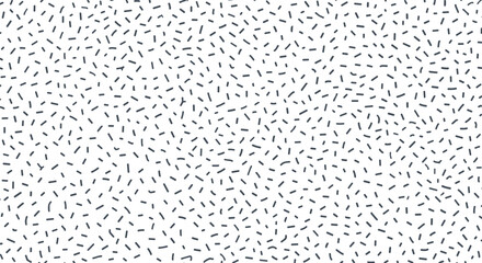 Fototapeta premium A close up of a white surface with tiny black confetti scattered in a randomized pattern.