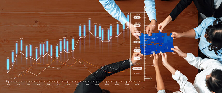 A diverse business team engages in collaborative strategy development, analyzing financial data and assembling puzzle pieces during a productive meeting at a wooden table. Scalp
