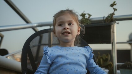 Smiling Child Enjoying Time Outdoors on a Rooftop