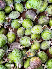 Closeup of a group pile of guava at an outdoor farmers market stall.