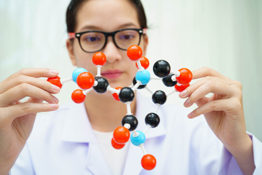 Scientist holding molecular model for chemical technology.