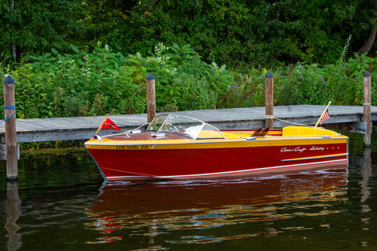 NISSWA, MN - 12 SEP 2024: Classic vintage wooden Chris Craft Holiday motorboat floating on the water, tied by rope to the dock on a Minnesota lake.