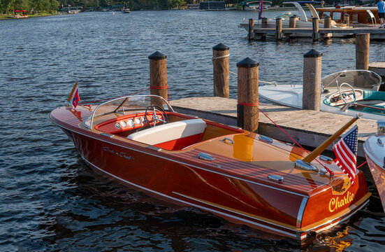 NISSWA, MN - 12 SEP 2024: Classic vintage wooden Chris Craft Capri motorboat floating on the water, tied by rope to the dock on a Minnesota lake.