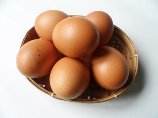 chicken eggs in a rattan plate on white background