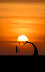 Vertical picture A basketball player shoots the ball against the stunning backdrop of the sunset