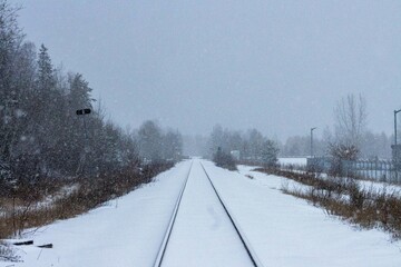 Canada, 10 November 2025 : Snow falling gently on railway tracks disappearing into distant fog